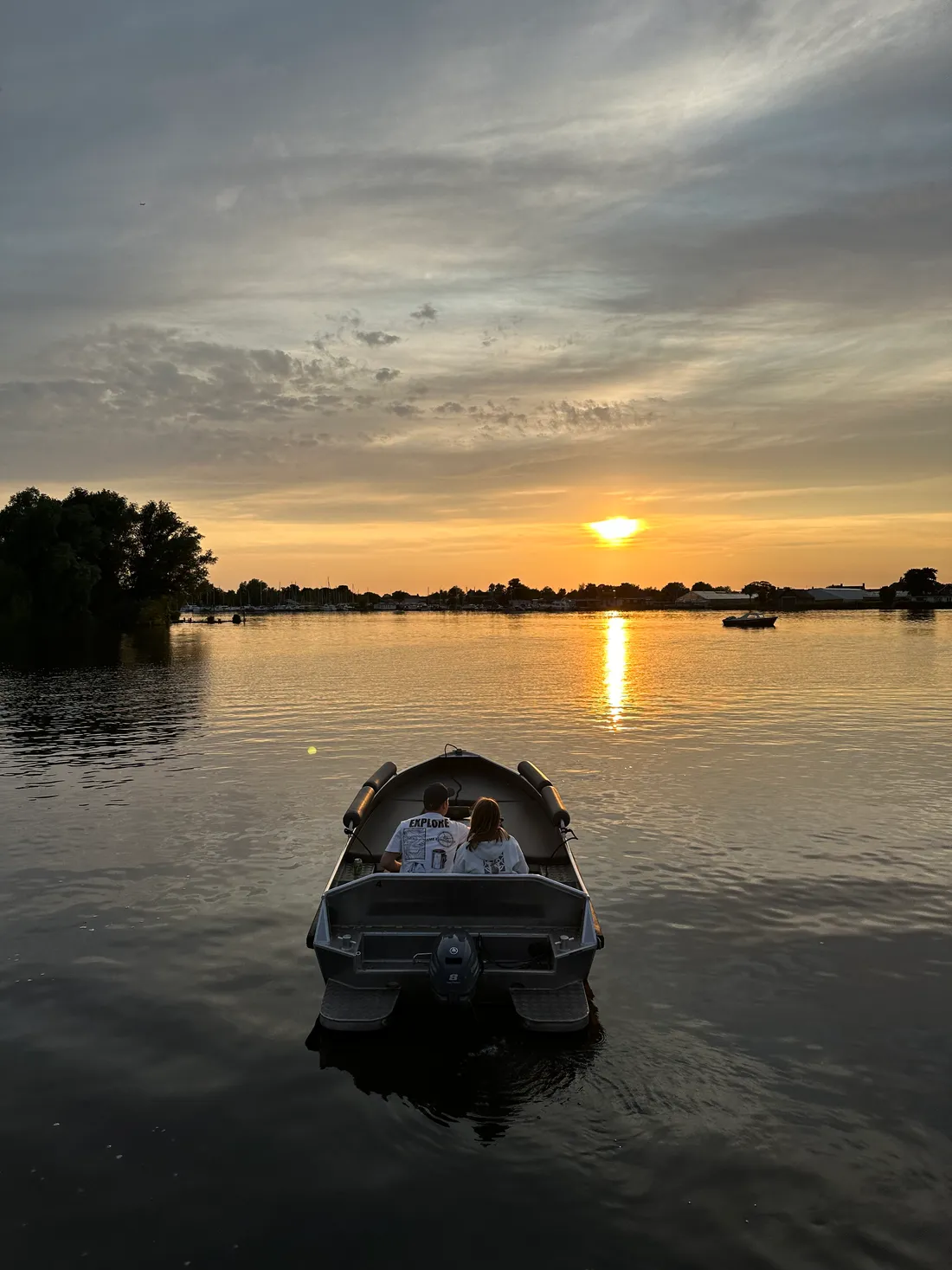 Two customers enjoying a rental boat trip at sunset